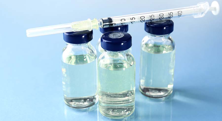 Vials of liquid with a needle resting on top